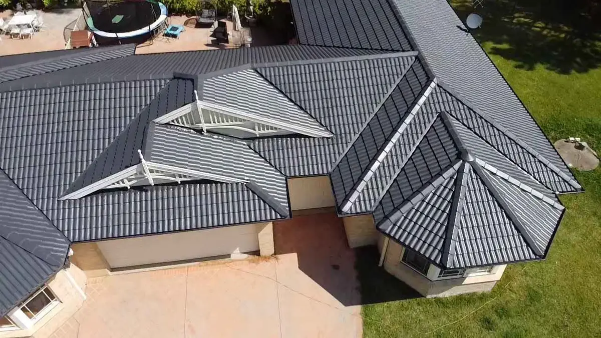 Restored charcoal concrete tile roof with white gable trim on a Central Coast home