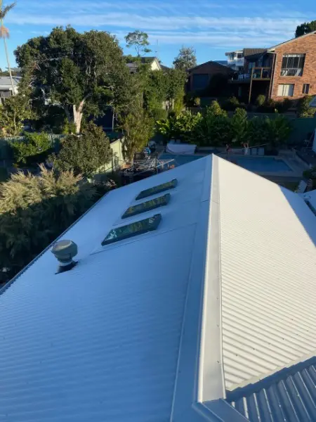 Pale metal roof with three skylights and a whirlybird vent