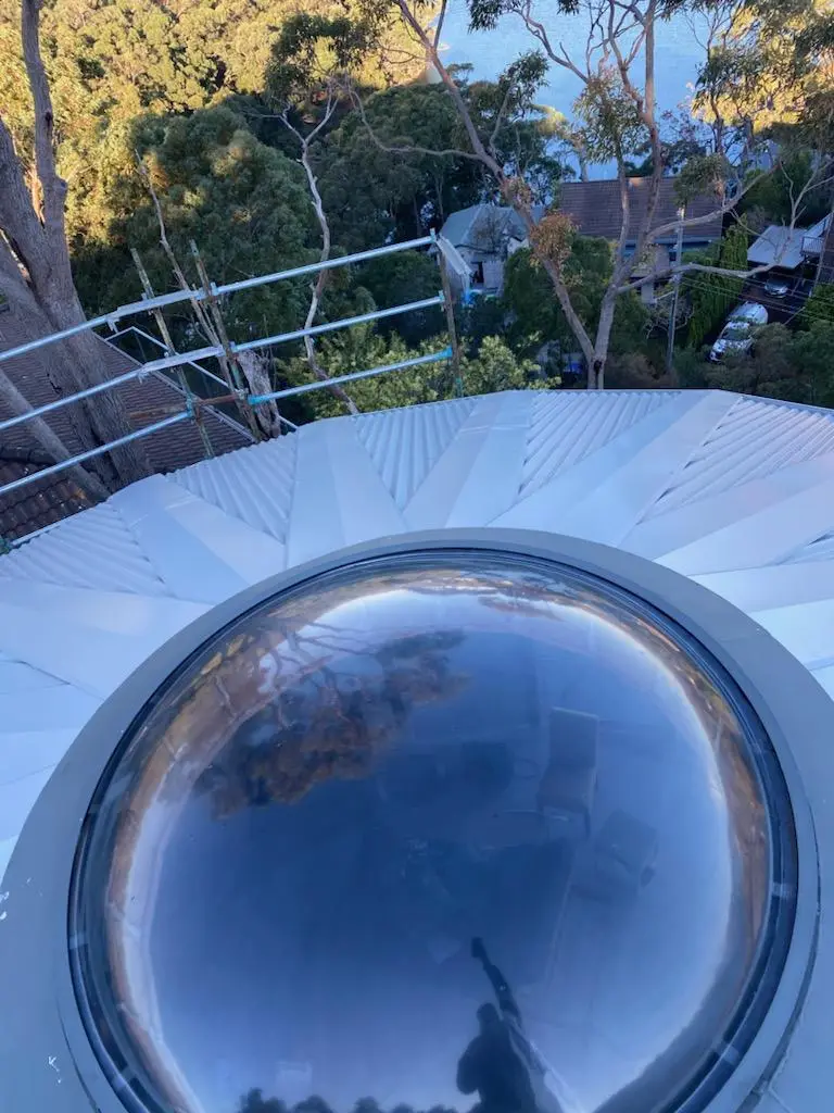 The finished octagonal metal roof with a clear dome skylight fitted at its peak