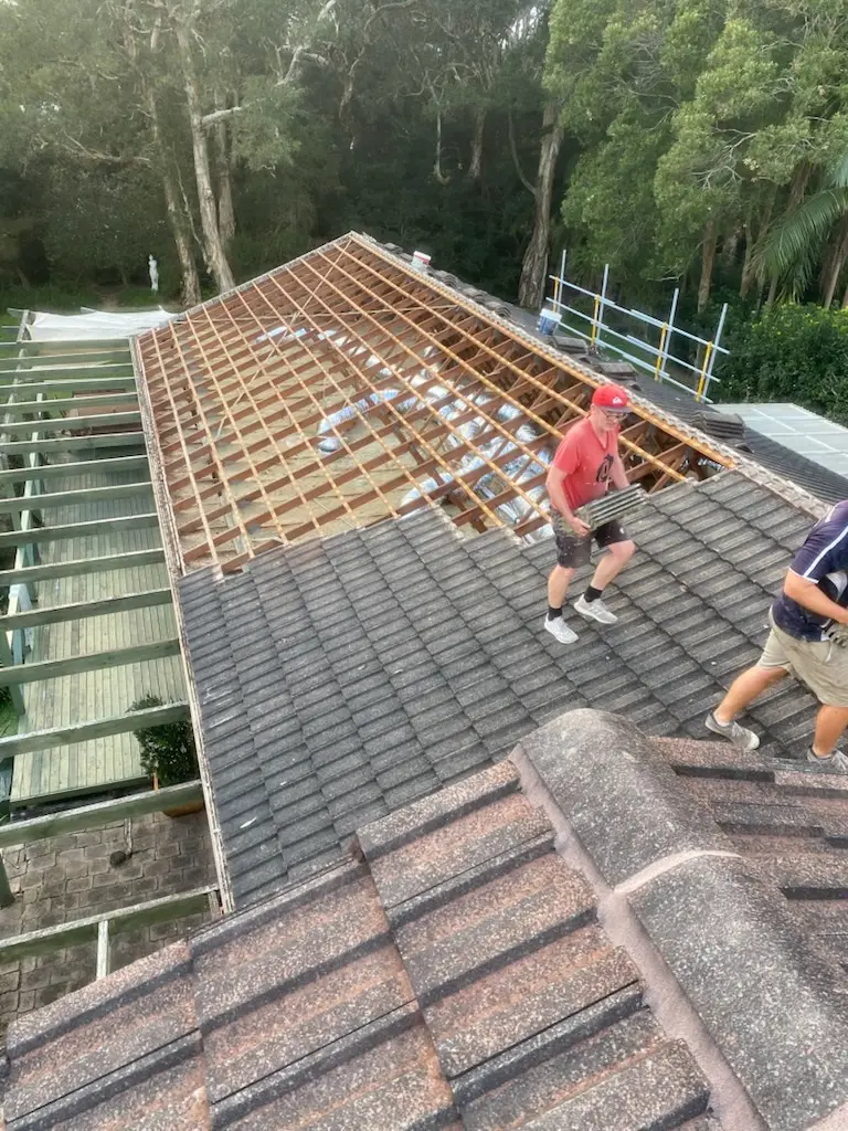 Our roofers stripping old concrete tiles back to the battens during a tile to metal roof replacement