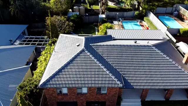 Tile roof in Wamberal repainted in Colorbond Basalt on a two storey brick home