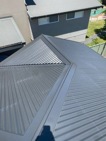 Grey metal re-roof with crisp hip and valley flashing — Roof Restorations & Replacements Central Coast